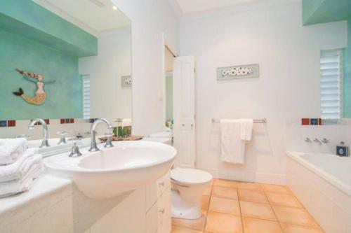 a bathroom with a sink and a toilet and a tub at Beauty tiny Walk To Sea in Port Douglas