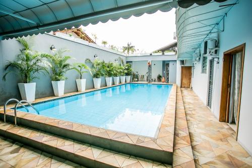 a swimming pool on the side of a house with plants at Dein Haus Pousada in Pomerode