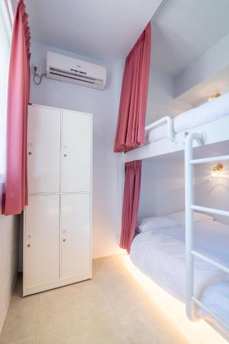a bedroom with a bunk bed with red curtains at W3 HOSTEL in Luodong