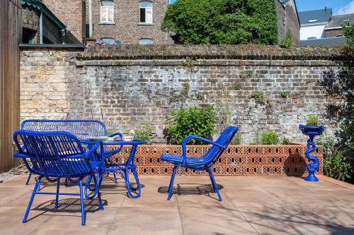 three blue chairs and a table on a patio at Island in Island, B&B boutique, Design et Vintage in Namur