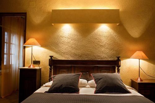 a bedroom with a bed with two lamps on it at Can Vila in Sant Julià del Llor