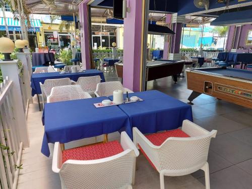 un restaurante con mesas y sillas azules y una mesa de billar en Garden Guest House, en Pattaya central