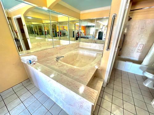 Luxury Inn Liberty في ليبرتي: حمام مع حوض كبير مع دش