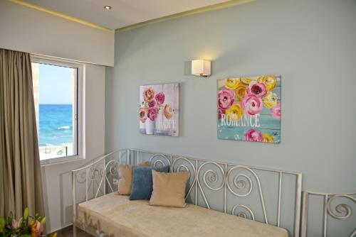 a bedroom with a bed and two pictures on the wall at Princess Irini Sea Front ApartHotel in Rethymno