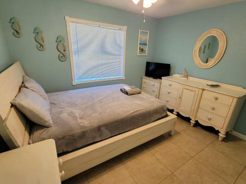 a bedroom with a bed and a sink and a mirror at Hidden Oasis in West Palm Beach