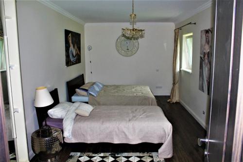 um quarto com 2 camas e um lustre em Forest house for family em Lebeniškiai
