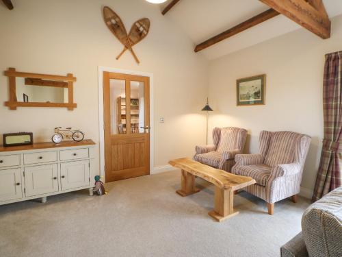 a living room with two chairs and a table at Horsley Cottage in Consett