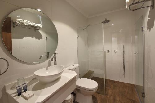 a bathroom with a toilet and a sink and a mirror at Romano Hotel Boutique in Safed