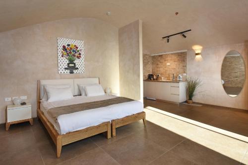 a bedroom with a large bed and a kitchen at Romano Hotel Boutique in Safed