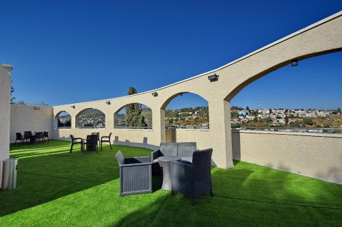 a patio with chairs and tables on the grass at Romano Hotel Boutique in Safed