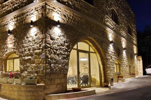 a stone building with a window and lights on it at Romano Hotel Boutique in Safed
