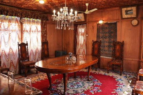 a dining room with a table and chairs and a chandelier at Chicago Group of Houseboats in Srinagar