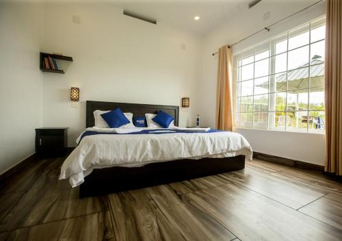 Ένα ή περισσότερα κρεβάτια σε δωμάτιο στο White Stone Vagamon Hilltop Cottage by VOYE HOMES