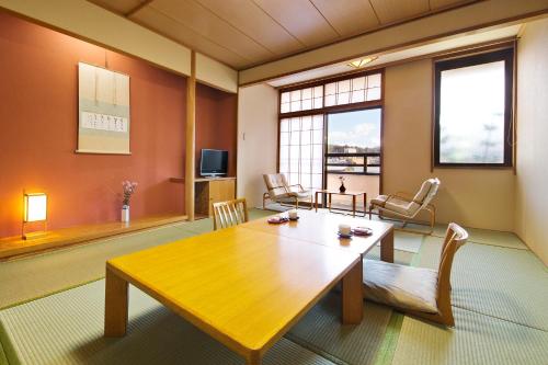 a living room with a wooden table and chairs at Honjin Hiranoya Annex in Takayama