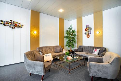 a living room with two couches and a table at Aqualux Wellness- & Tagungshotel in Bad Salzschlirf