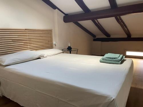 Una cama blanca grande con una toalla encima. en portanova attic en Bolonia