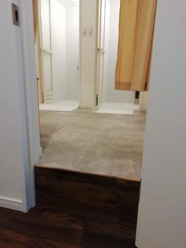 a hallway of a room with white walls and wood floors at B&B Surf Rider-ゲストハウスタイプ in Kamakura