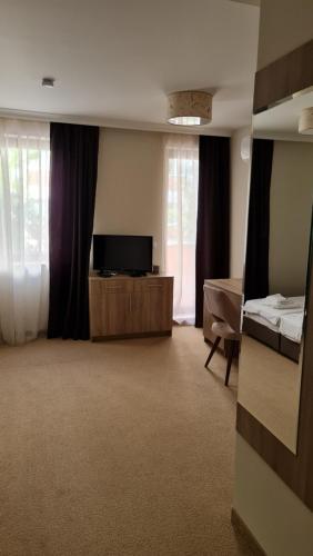 a room with a tv and a bed and curtains at Hotel Geppy in Sofia