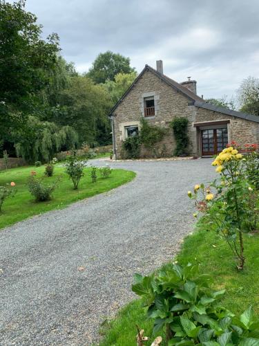 a gravel road in front of a stone house at Le paradis des oiseaux in Saint-Gildas