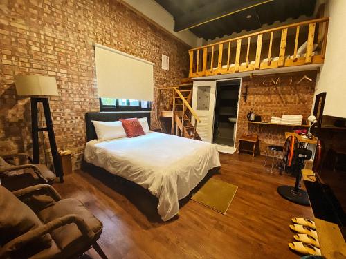 a bedroom with a bed and a brick wall at Red brick 642 B&B in Puli