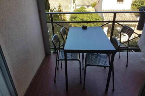 a blue table and chairs on a balcony at jolies studios avec piscines et parking privé 800m de la plage le grau du roi in Le Grau-du-Roi