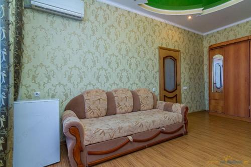 a living room with a couch and a table at База отдыха "Изумруд" in Mostovskoy