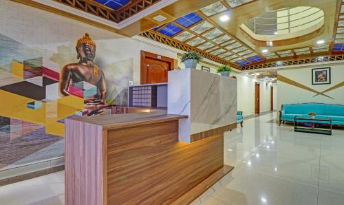 a lobby with a mural of a statue on the wall at Eesha Elite in Visakhapatnam