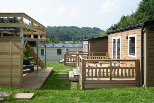 un patio trasero con terraza y cabina en Tiny House en Enscherange