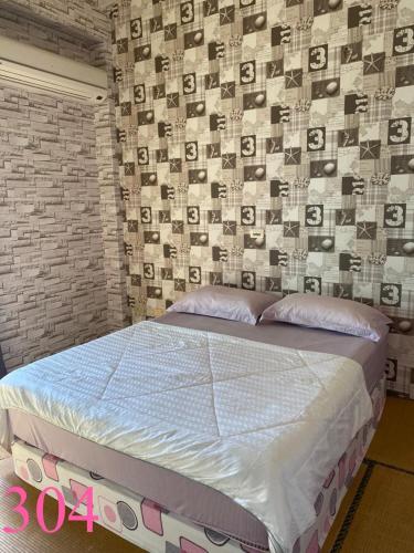 a bed in a room with a brick wall at Fly House 飛航家民宿 in Hualien City