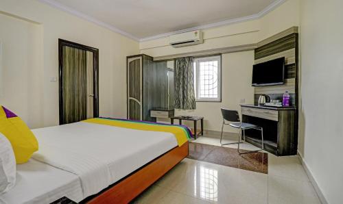a bedroom with a bed and a desk with a computer at Eesha Elite in Visakhapatnam