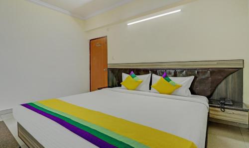 a white bed with a rainbow blanket on it at Eesha Elite in Visakhapatnam