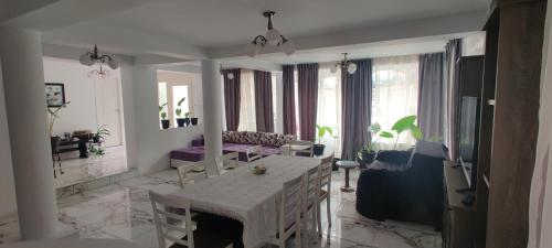 a living room with a white table and a couch at Casa Narcisa in Băile Herculane