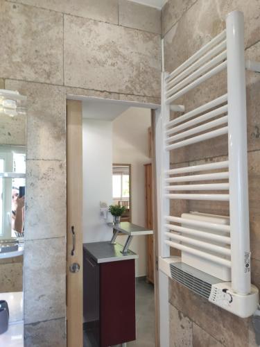La salle de bains est pourvue d'un mur en pierre, d'un bureau et d'un miroir. dans l'établissement Joli studio au calme, à Toulon