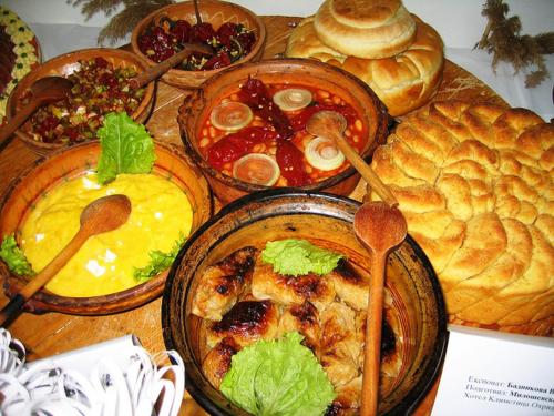 stół z wieloma miskami jedzenia i chleba w obiekcie Villa Majda w mieście Peštani