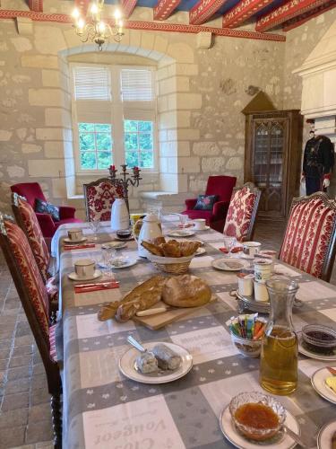ein Esszimmer mit einem Tisch mit Essen darauf in der Unterkunft Château de Ré in Le Petit-Pressigny