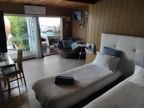 1 dormitorio con 1 cama y sala de estar con patio en Room near the airport en Maia