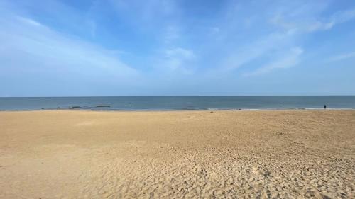 a sandy beach with the ocean in the background at Cozy Private Static Caravan at Llyons Robin Hood - Silver Birch Way 11 in Rhyl