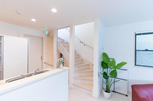 a staircase in a white room with a mirror at CuteFamilyHouse! 6minShinjuku 6minSta FreeParking Cozy,Bright KidsFree Under6yrs in Tokyo