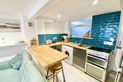 a kitchen with a couch and a table in a kitchen at Traditional 2-bedroom Cornish cottage in Newlyn in Newlyn