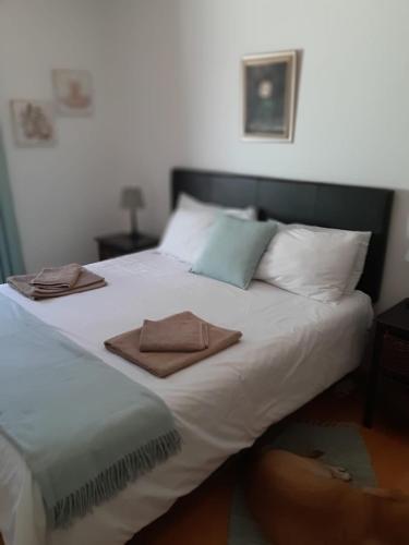 a large white bed with two towels on it at Olive Tree Cottage in Paternoster