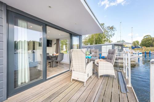 a deck with chairs and a table on the water at Marina Martinshafen in Sassnitz
