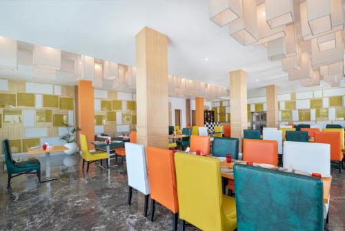 a dining room with colorful chairs and tables at Radisson Hotel Bareilly Airport in Bareilly