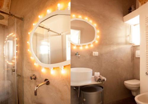 a bathroom with a mirror and a sink with lights at View - Art house Roof top sea view in Polignano a Mare