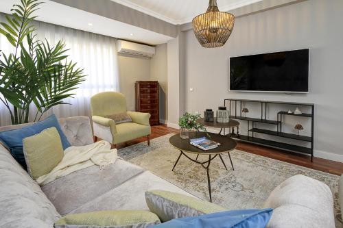 sala de estar con sofá y TV en Living4Malaga Soho Orangerie Deluxe, en Málaga