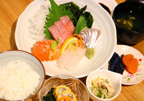 a plate of food with sushi and rice on a table at APA Hotel Matsuyamajo Nishi in Matsuyama