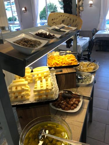 un buffet con diferentes tipos de queso y otros alimentos en Hotel Apartamentos Solimar, en Calafell