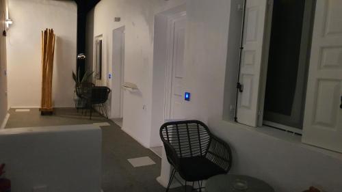 a black chair sitting in a room with a door at Mykonos Double Luxury Mini Suites-With External Hot spa Adults only in Ano Mera