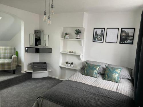 a bedroom with a bed and a chair and shelves at Luxury stay in the heart of Porthcawl in Porthcawl