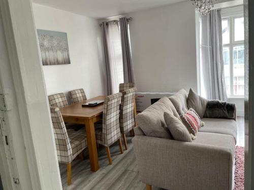 a living room with a couch and a table at Luxury stay in the heart of Porthcawl in Porthcawl