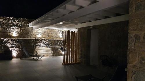 a room with a stone wall with a table and chairs at Mykonos Double Luxury Mini Suites-With External Hot spa Adults only in Ano Mera